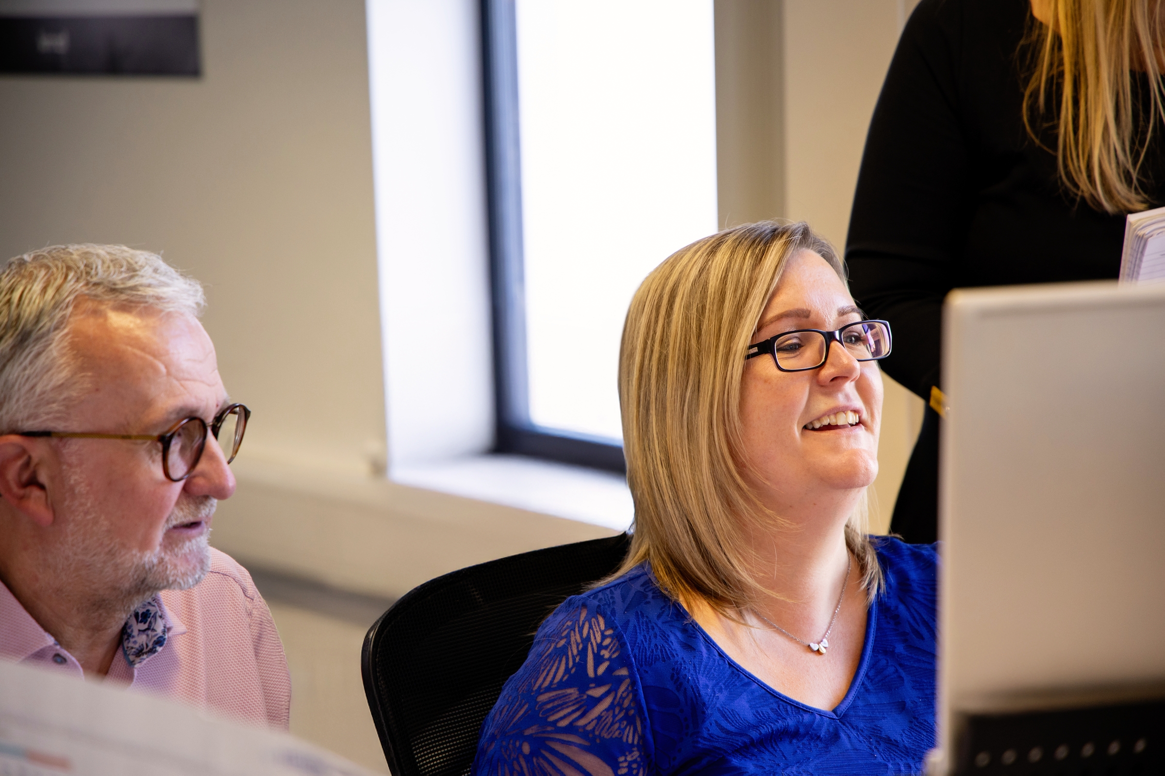 Two Mivida colleagues smiling at a screen