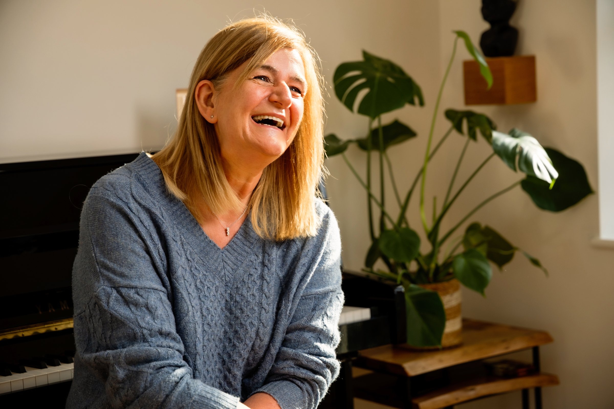Mivida client laughing sat at a piano